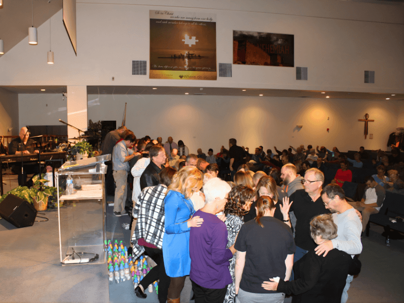 Families praying together at the altar during a Teen Challenge graduation