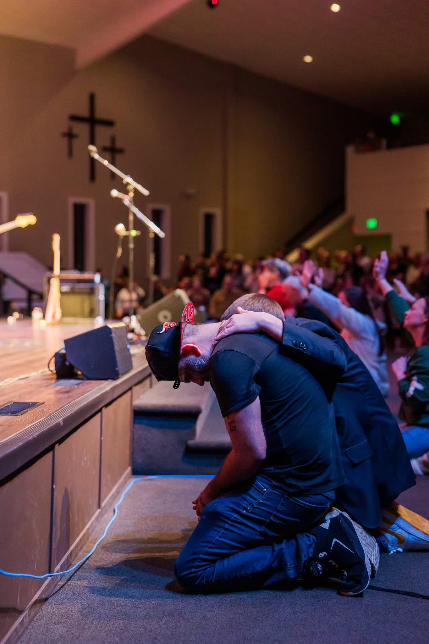 Men praying at an altar during a Teen Challenge service