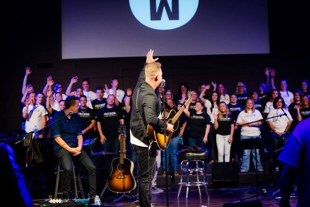 Matthew West on stage with Shenandoah Valley Teen Challenge student choir in Freedom From Addiction shirts at Winchester Church of God