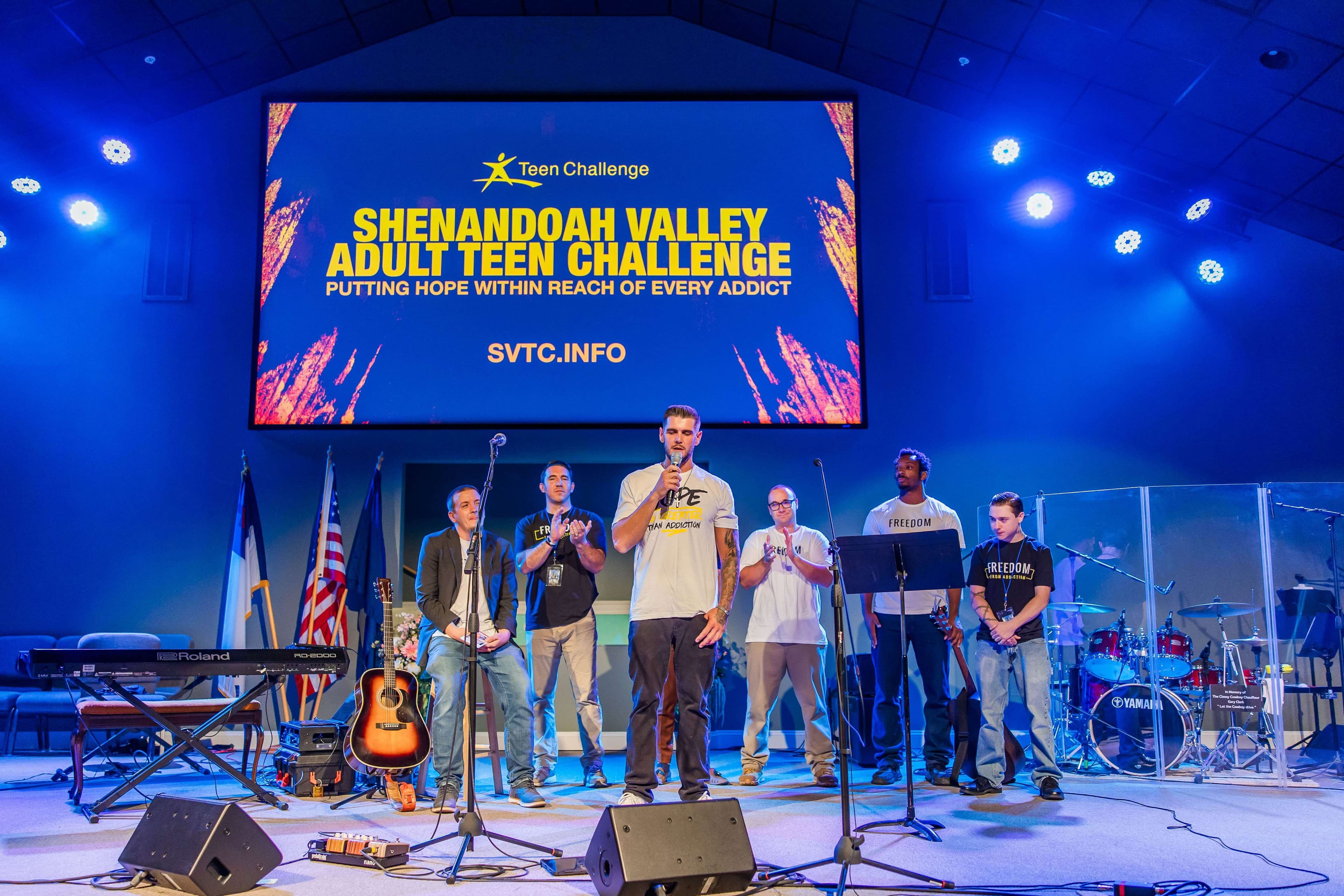 Shenandoah Valley Teen Challenge students worshipping and testifying on stage at a community event