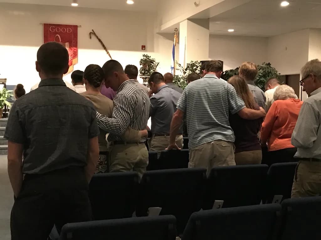 Men standing together during a chapel prayer service at Shenandoah Valley Teen Challenge