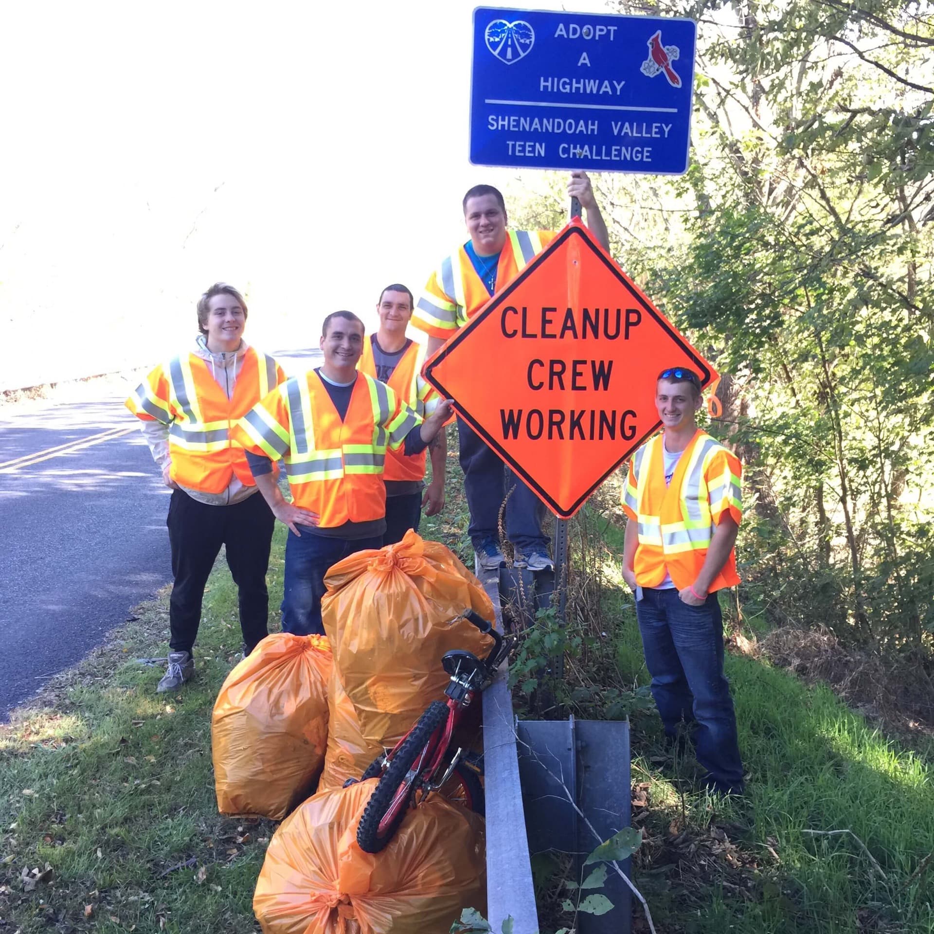 Men in safety vests working together on a highway cleanup crew
