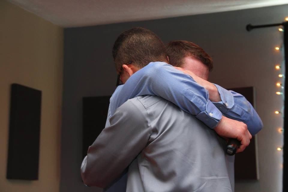 Two men embrace after a testimony at a Shenandoah Valley Teen Challenge gathering, one comforting the other
