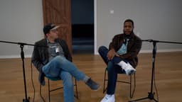 Rob Grant and Justin Franich sitting together talking in an empty chapel during a podcast recording.