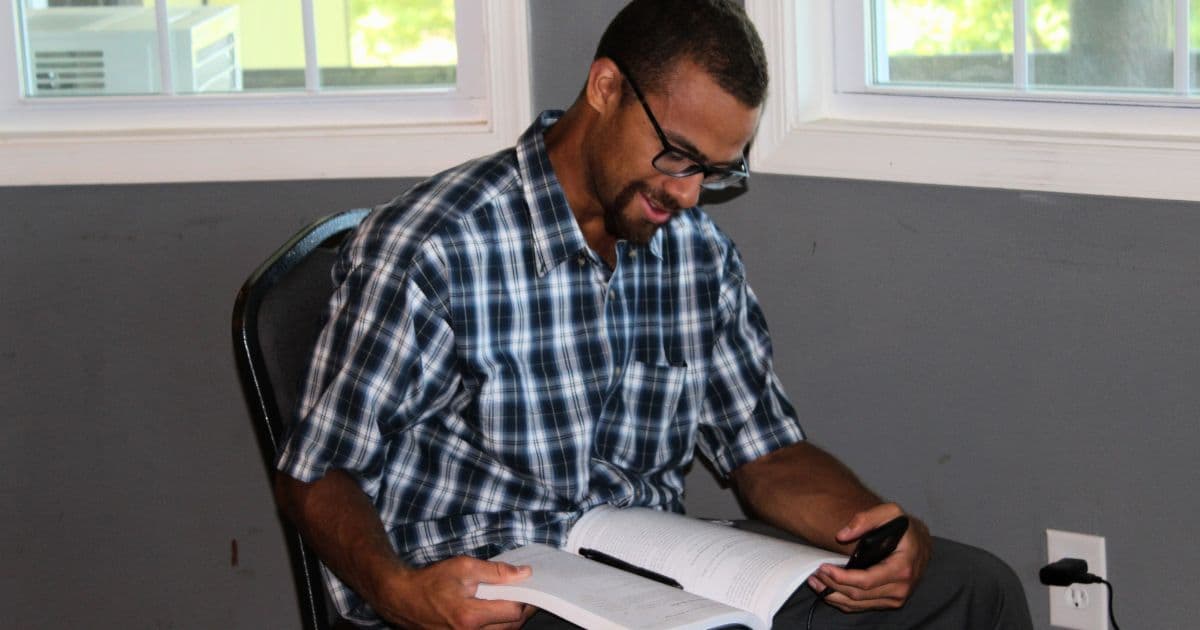 A man studying with a book open during a class at Teen Challenge