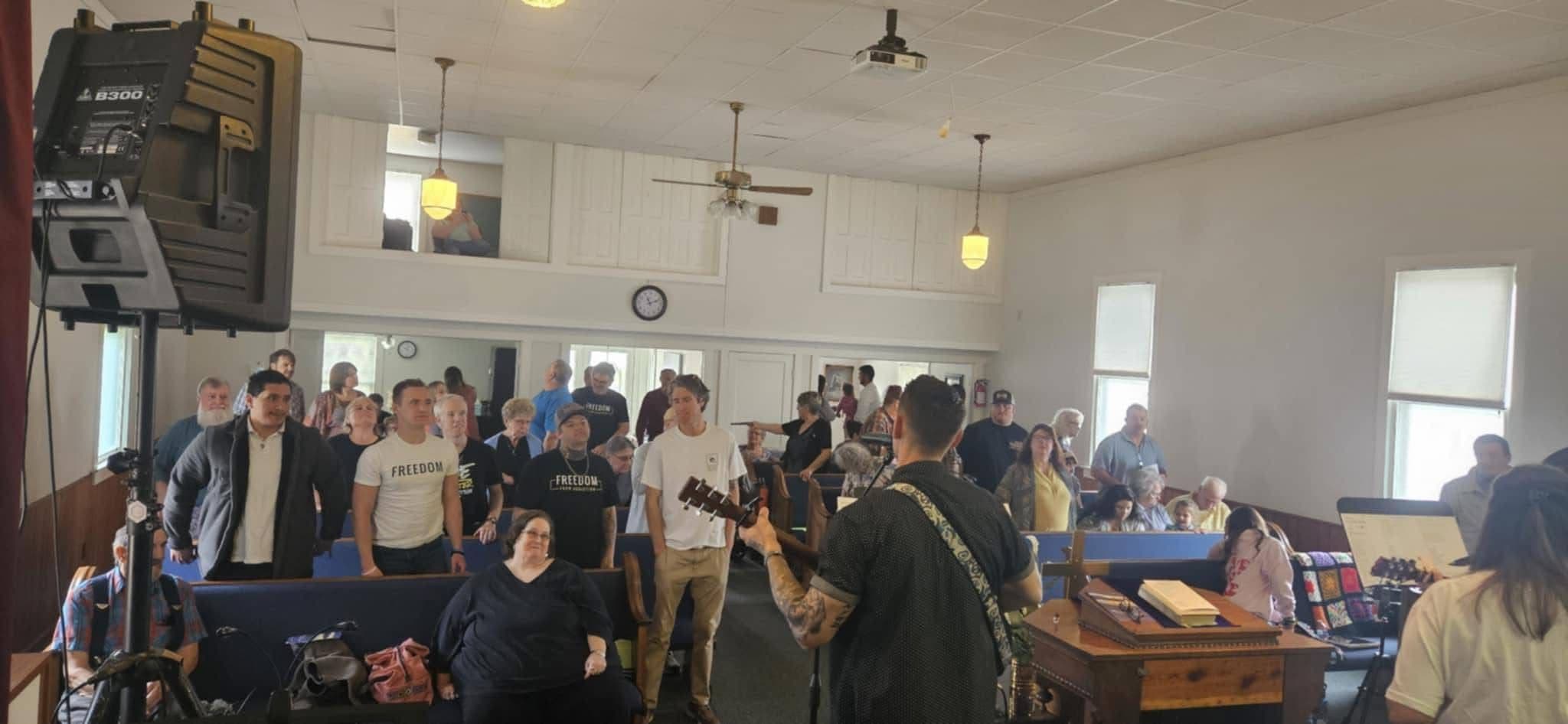 Worship during a Shenandoah Valley Teen Challenge service at Pleasant Hill Church of the Brethren in Crimora, Virginia. Full pews, live music, and the congregation on their feet.