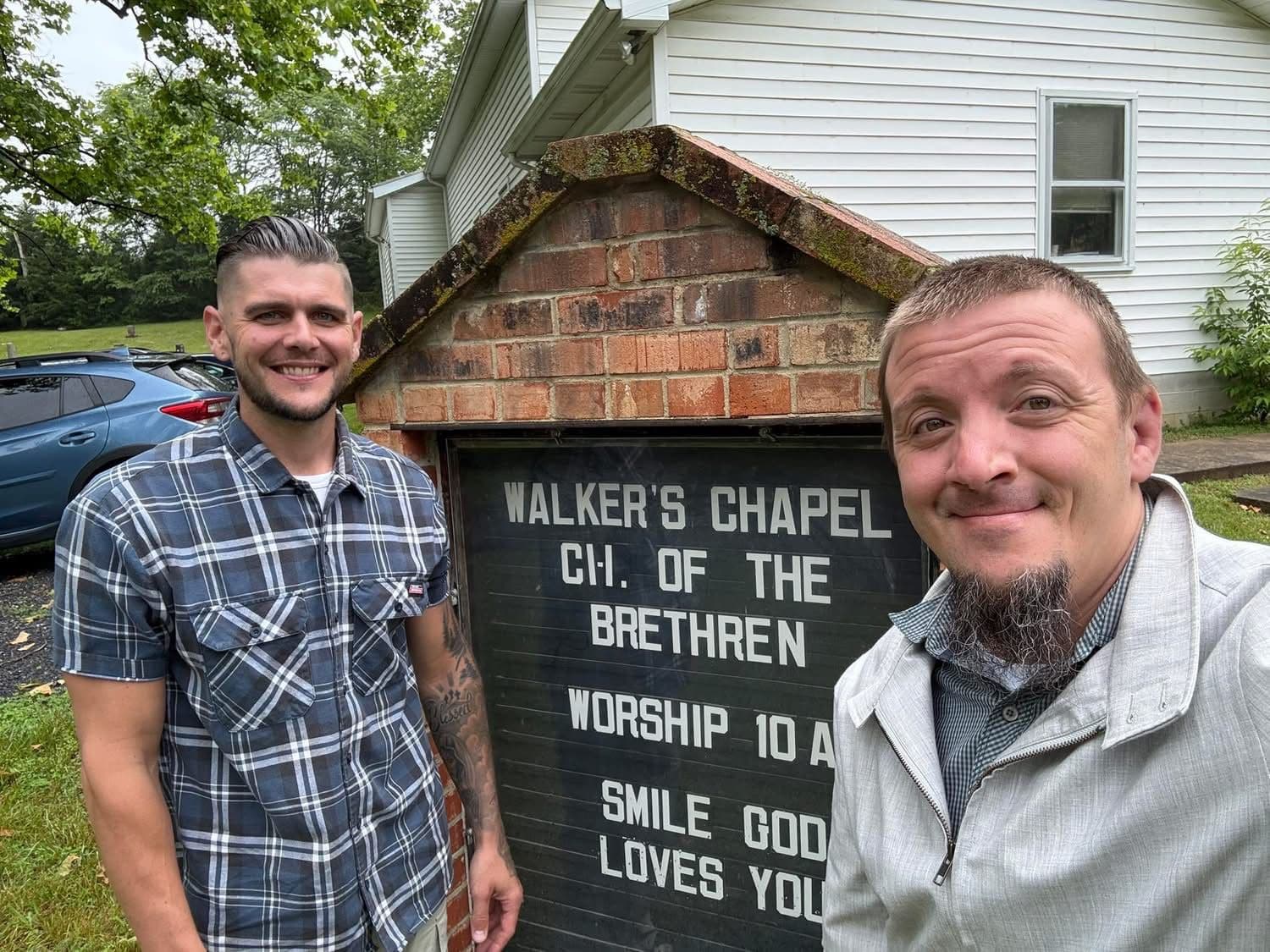 Justin Franich and Seth Via next to the Walker's Chapel Church of the Brethren sign in Mount Jackson, Virginia.